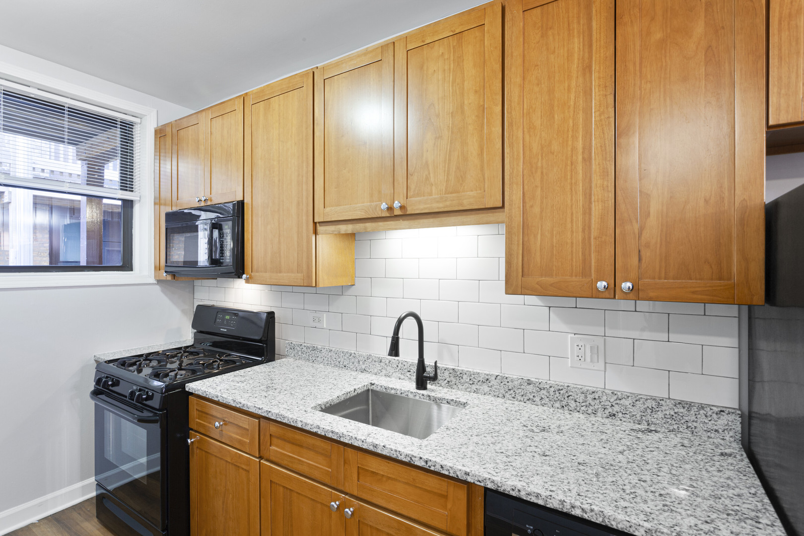 1702 West Juneway Terrace, Unit 3C Chicago, IL 60626 - Photo 4 of 15 a kitchen with stainless steel appliances granite countertop a sink stove and cabinets