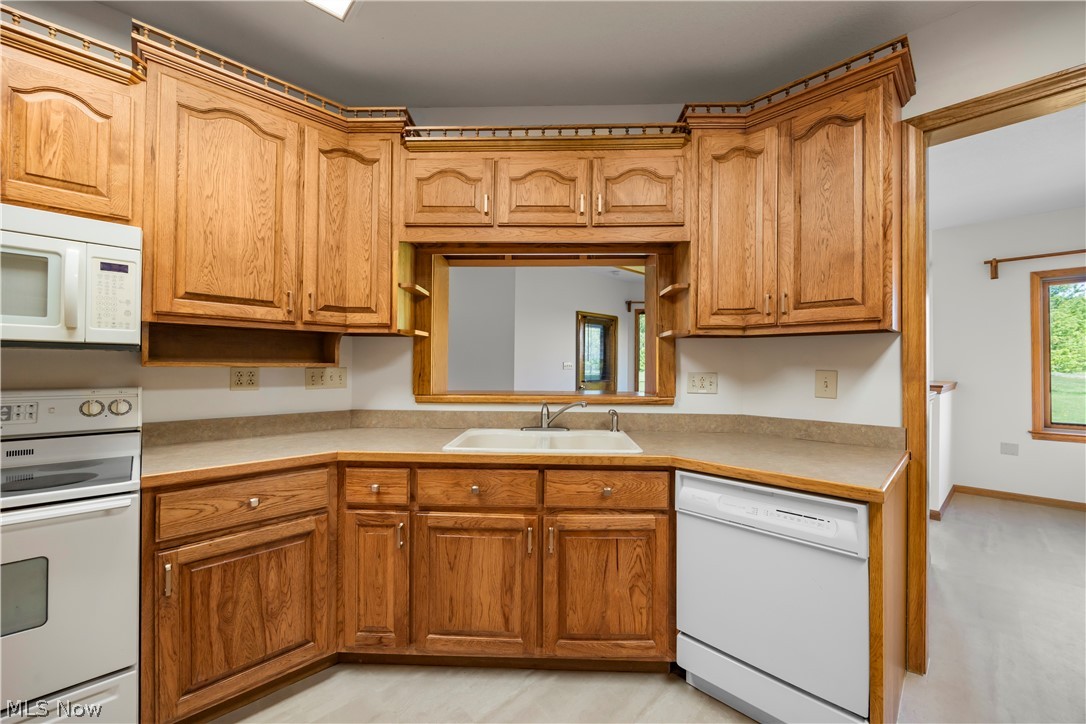 51488 Peck Wadsworth Road Wellington, OH 44090 - Photo 28 of 50 Kitchen featuring wood cabinetry, white appliances, a pass-through window, and light-toned countertops