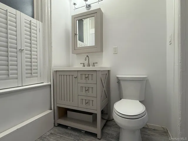 a bathroom with a toilet a sink a vanity and mirror