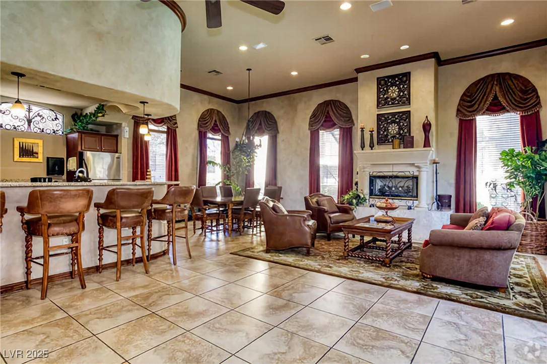 4400 South Jones Boulevard, Unit 2021 Las Vegas, NV 89103 - Photo 5 of 9 Living room featuring ornamental molding, recessed lighting, a glass covered fireplace, light tile patterned flooring, and ceiling fan