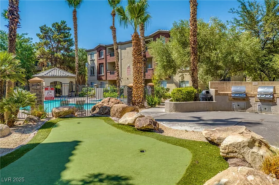 4400 South Jones Boulevard, Unit 2021 Las Vegas, NV 89103 - Photo 7 of 9 View of property's community with a putting area, an outdoor kitchen, and a patio