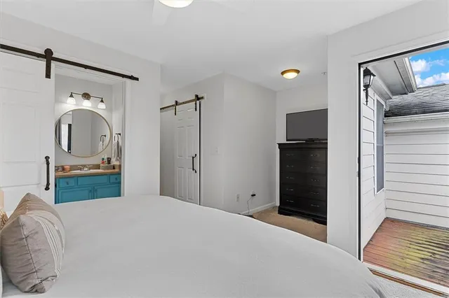 a bedroom with a bed and a mirror on the dresser