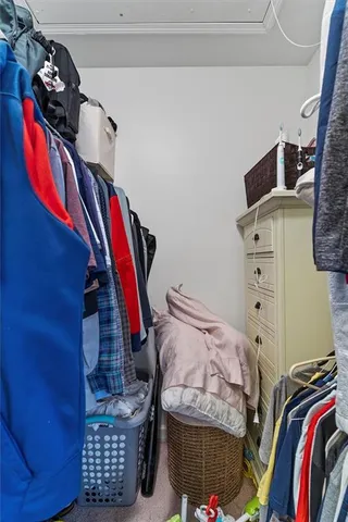 a view of walk in closet with clothes and shoes