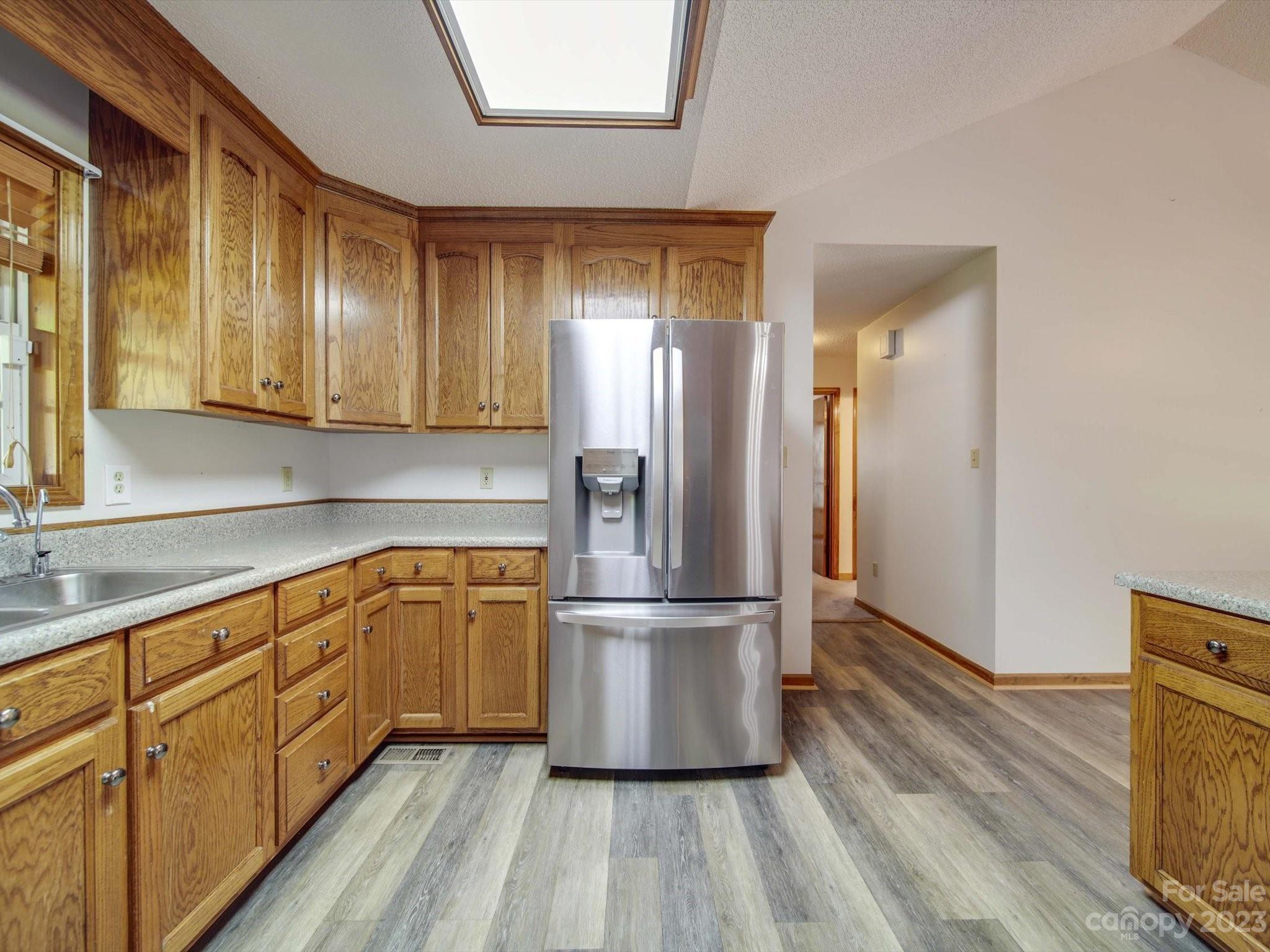 5351 Faith Road Salisbury, NC 28146 - Photo 7 of 32 a kitchen with stainless steel appliances granite countertop a refrigerator a sink and wooden floors