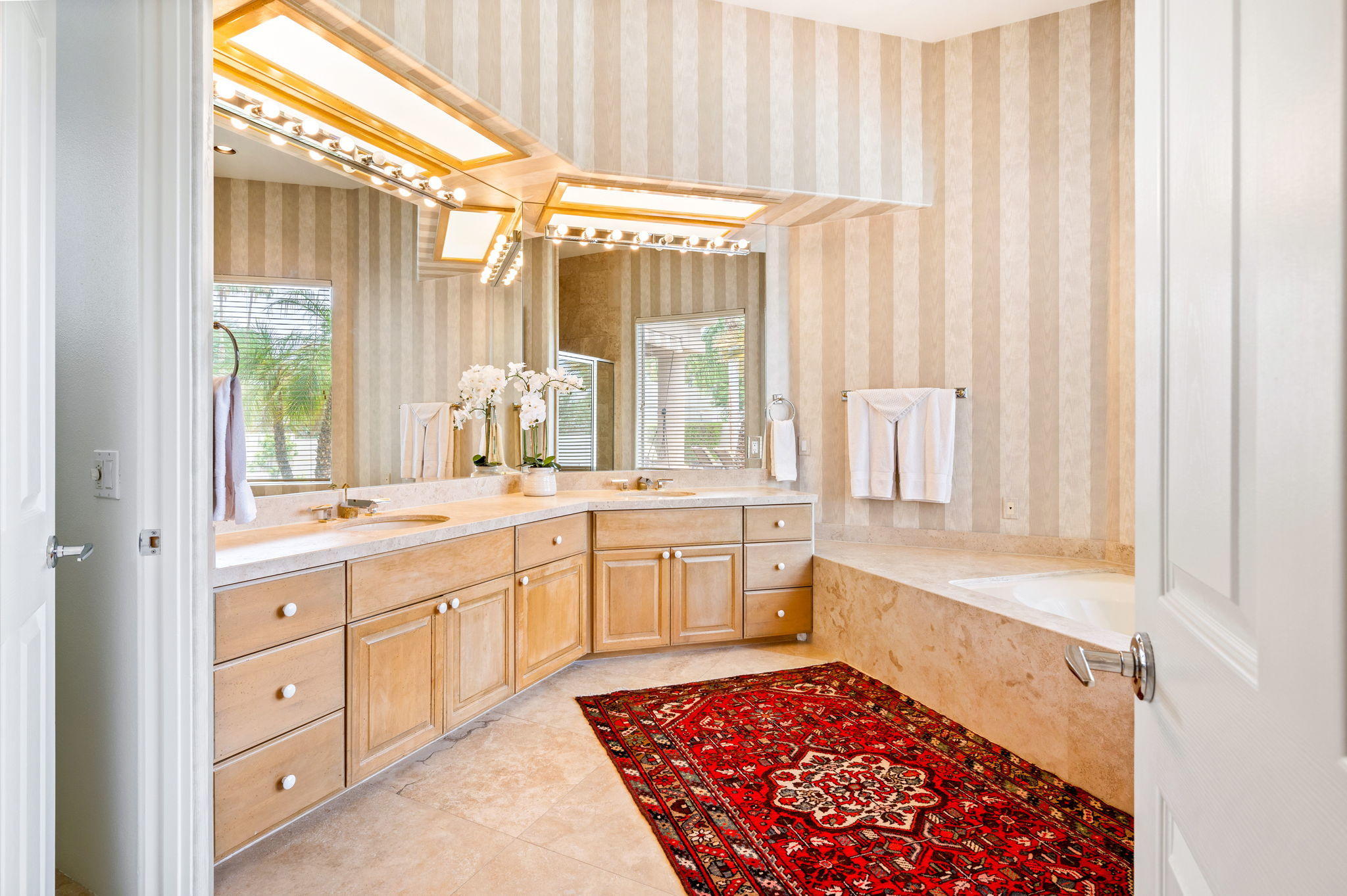 70615 Sunny Lane Rancho Mirage, CA 92270 - Photo 23 of 41 a large bathroom with a double vanity sink a large mirror and a bathtub next to a window