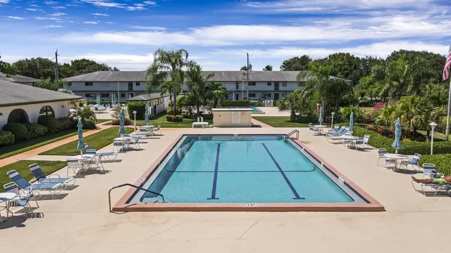 a view of swimming pool with outdoor seating and a garden