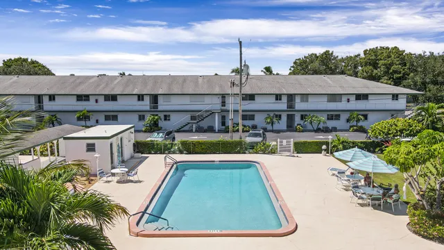 a view of a house with pool lawn chairs and a yard