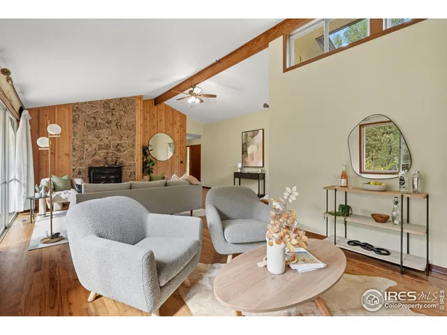 a living room with fireplace furniture and a large window
