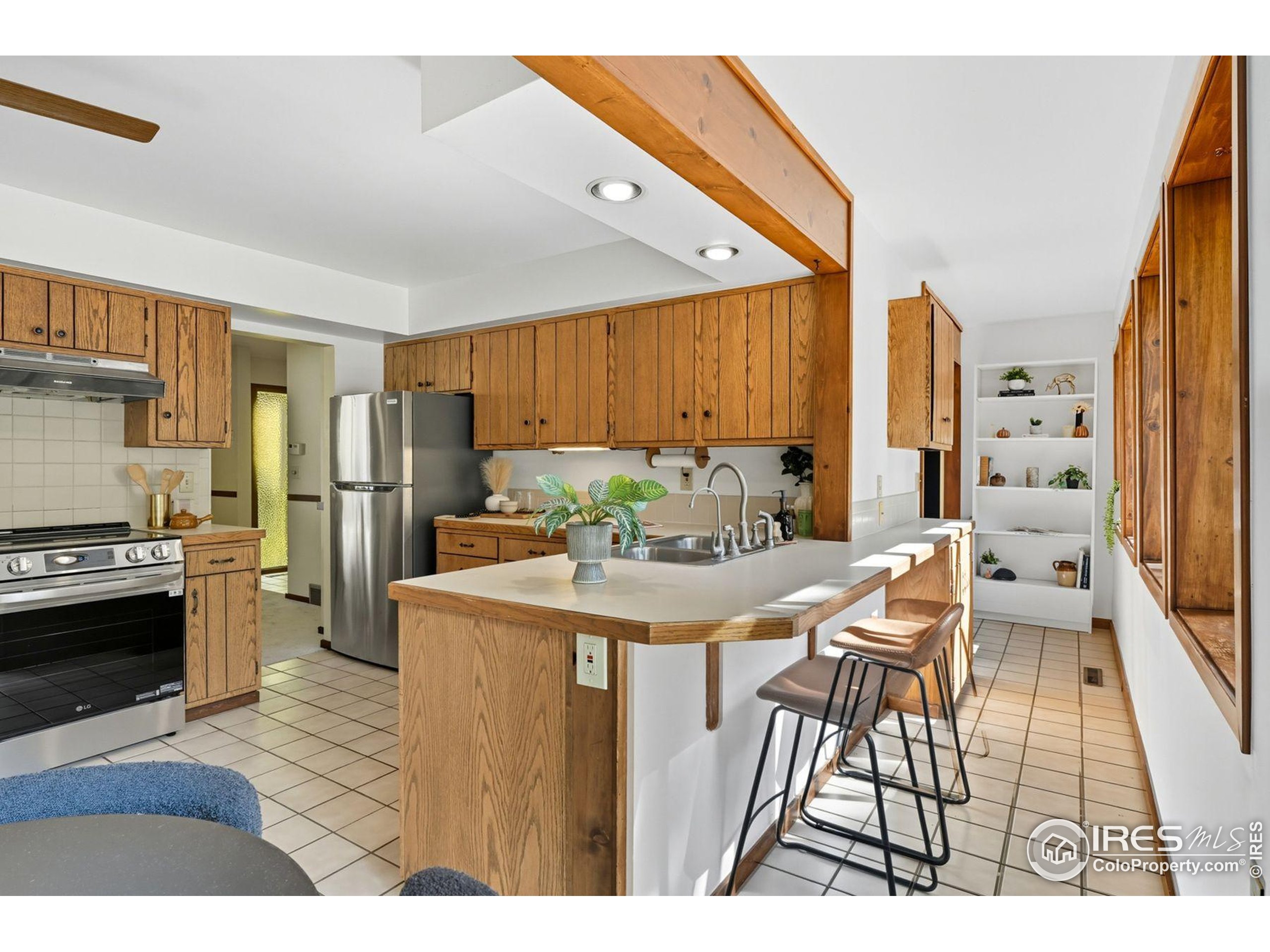 1037 Wagonwheel Gap Road Boulder, CO 80304 - Photo 25 of 43 a kitchen with stainless steel appliances kitchen island granite countertop a refrigerator a stove a sink dishwasher and a dining table with wooden floor