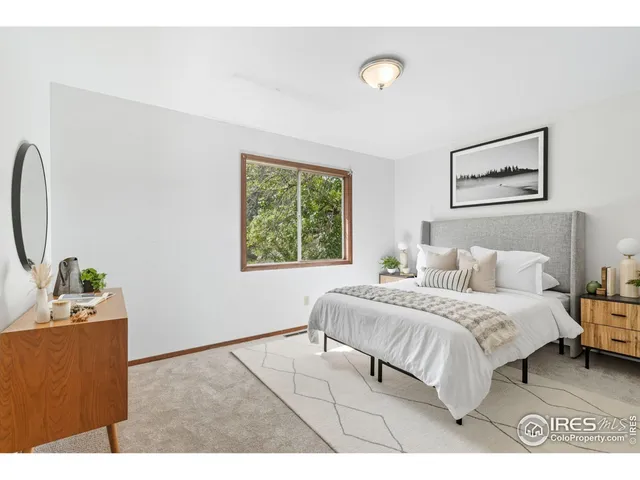 a bedroom with a bed and a large window