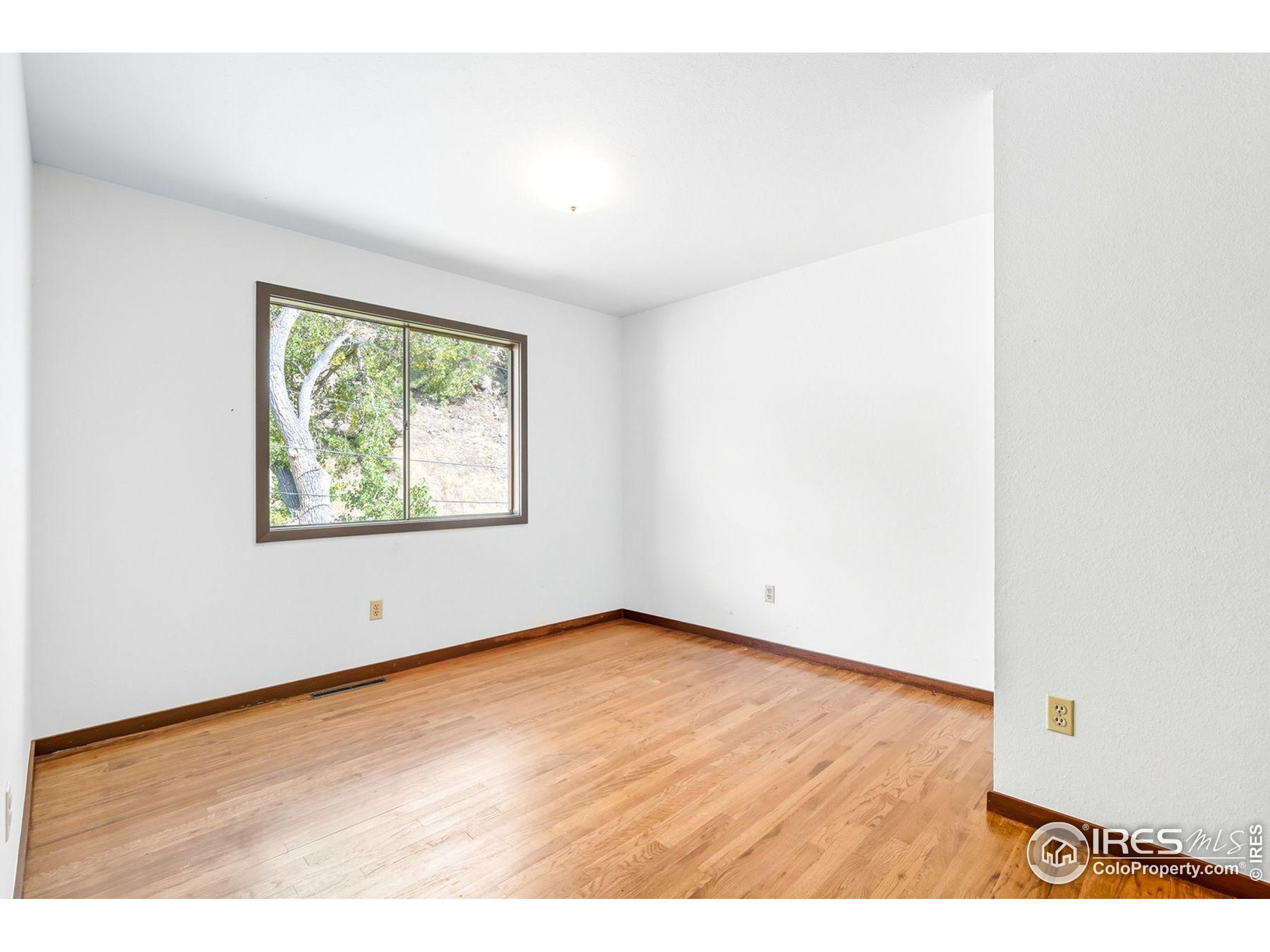 1037 Wagonwheel Gap Road Boulder, CO 80304 - Photo 35 of 43 a view of an empty room with wooden floor and a window