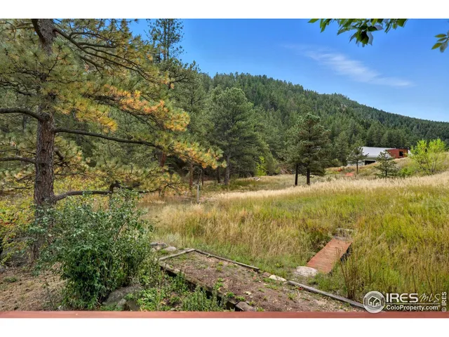 an aerial view of residential houses with outdoor space and trees