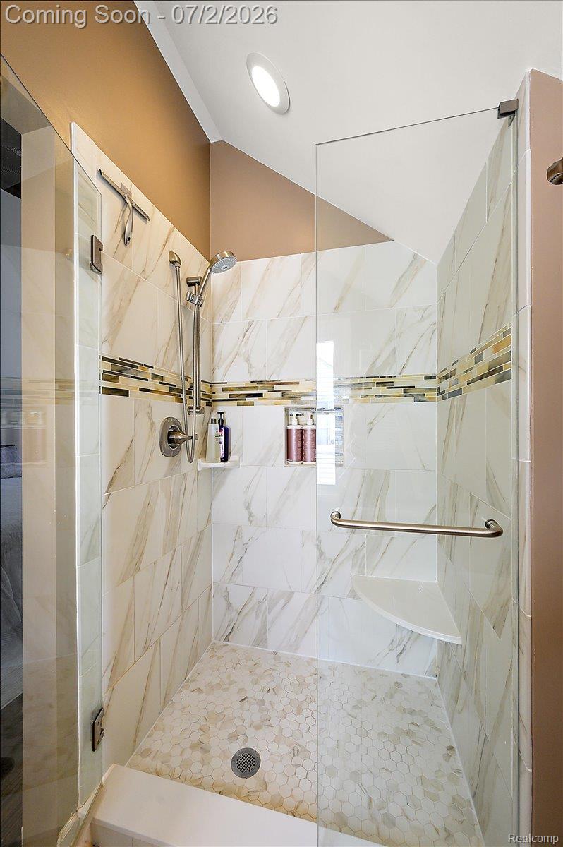 1706 Princeton Road Berkley, MI 48072 - Photo 27 of 49 Glass-enclosed shower featuring large format tile walls, hexagonal mosaic floor tile, and a built-in corner shelf