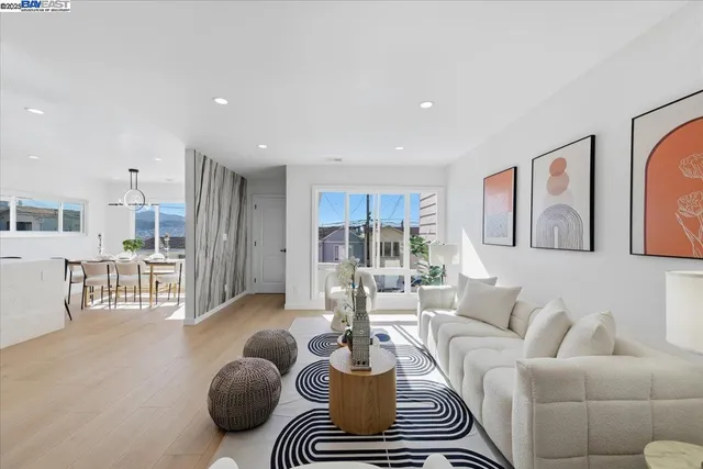 a large white kitchen with a stove a sink dishwasher and a fireplace with wooden floor