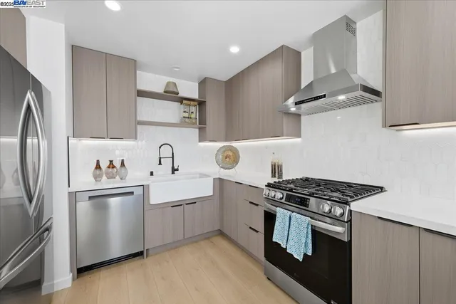 a kitchen with kitchen island stainless steel appliances a sink stove and refrigerator