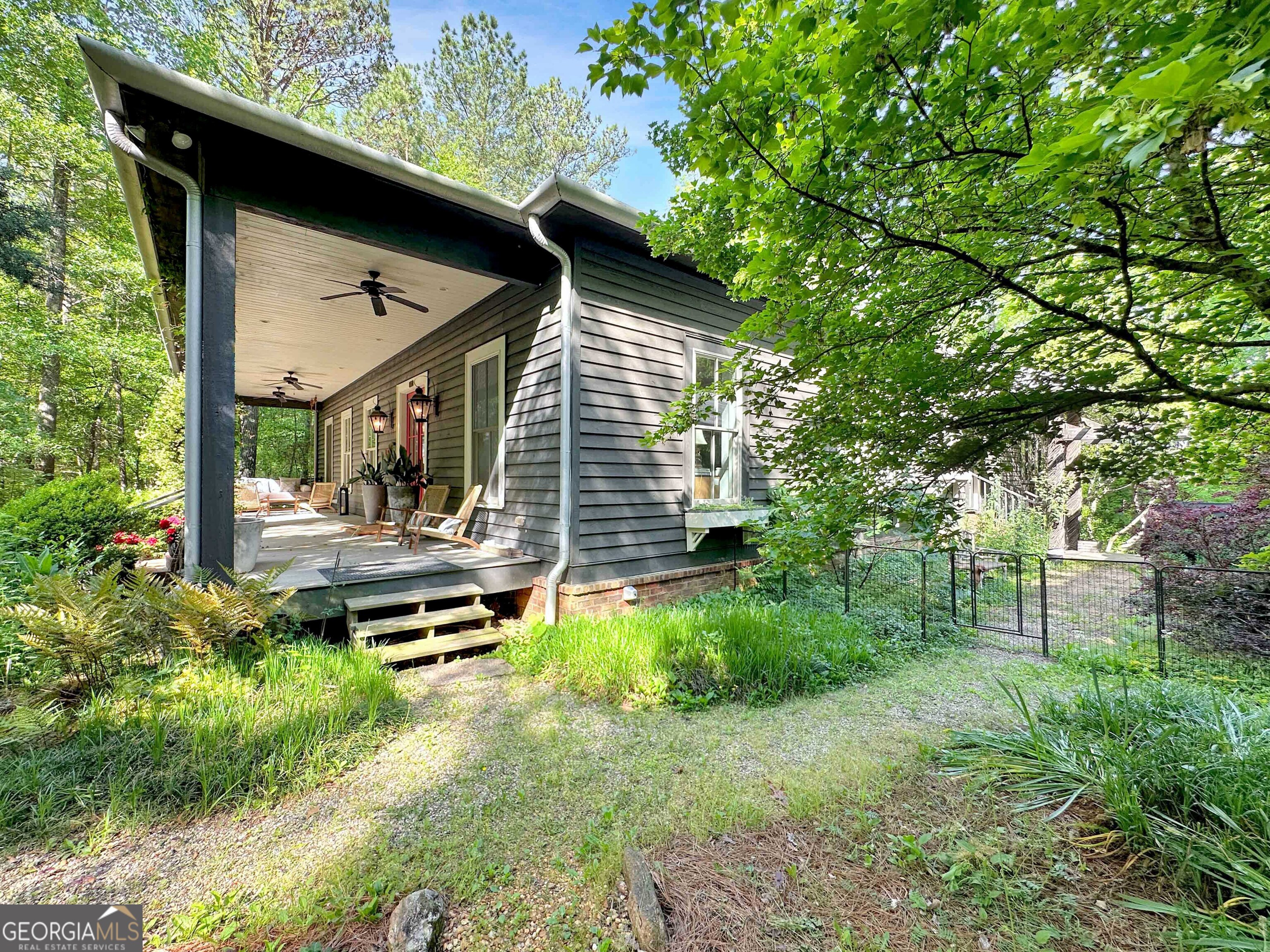 500 Augusta Lane Chattahoochee Hills, GA 30268 - Photo 3 of 49 a backyard of a house with lawn chairs plants and large tree