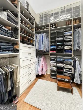 a view of walk in closet with clothes and shoes