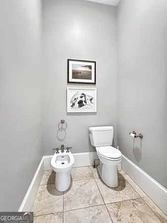 a white toilet sitting next to a white wall