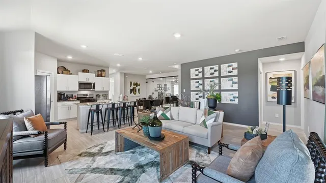 a living room with furniture a flat screen tv and a table