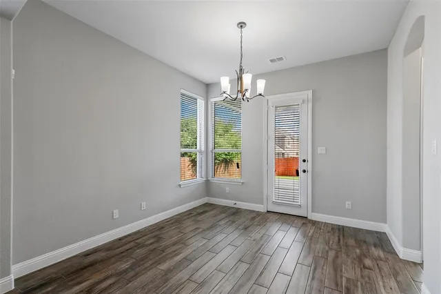 a view of empty room with wooden floor and window