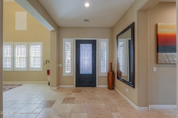 a living room with furniture a flat screen tv and a refrigerator