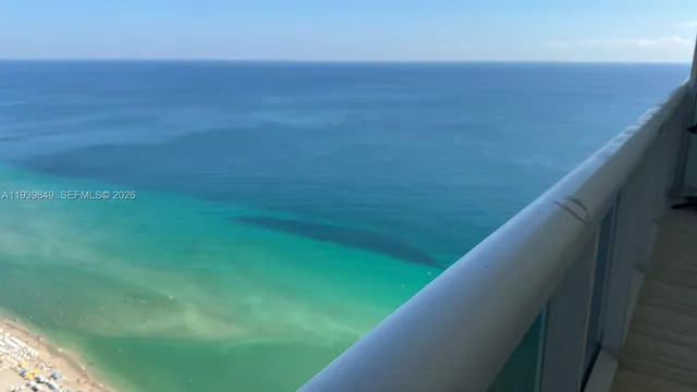 a view of a balcony with a yard