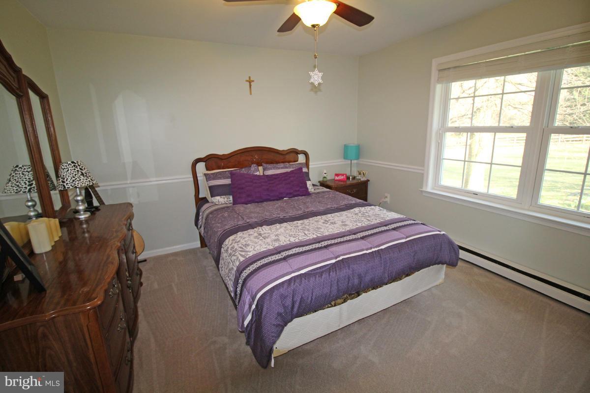 6603 South Clifton Road Frederick, MD 21703 - Photo 17 of 21 a bedroom with a bed and a chandelier