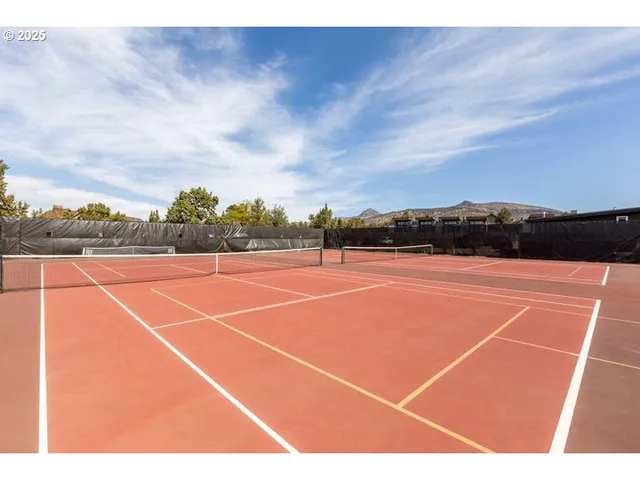 a view of a patio with a table and chairs under an umbrella with barbeque grill