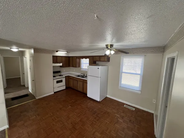a kitchen with stainless steel appliances kitchen island granite countertop a refrigerator and a stove top oven