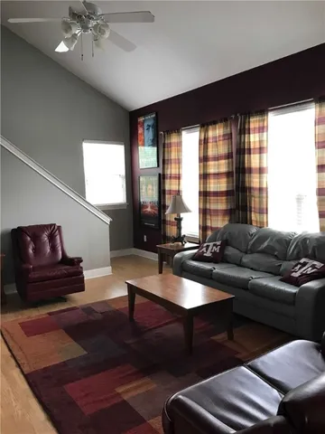 a living room with furniture a rug and a large window