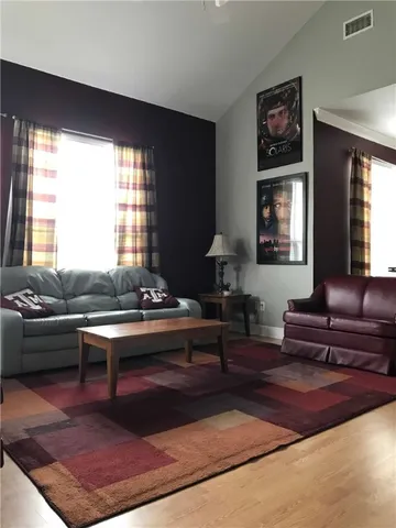 a kitchen with stainless steel appliances a sink a stove a refrigerator cabinets and a dining table