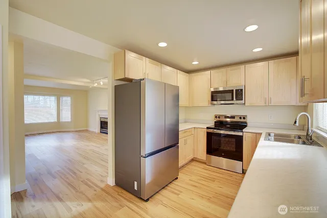 a kitchen with stainless steel appliances granite countertop a refrigerator stove microwave and sink