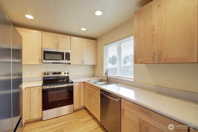 a kitchen with a sink stove top oven and refrigerator
