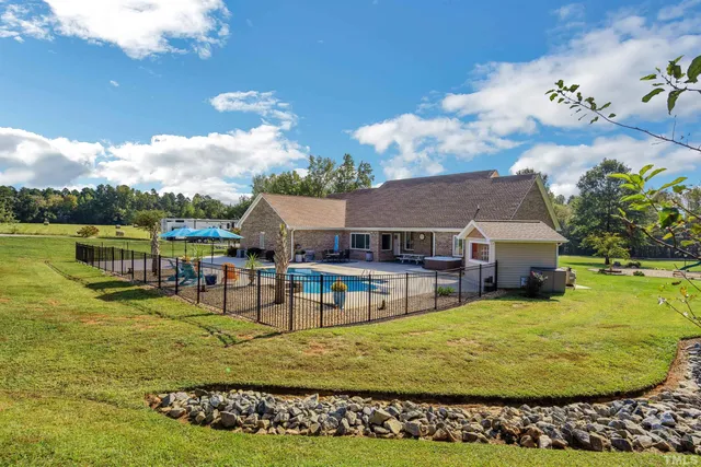 an aerial view of a house with swimming pool and large trees