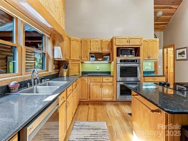a kitchen with stainless steel appliances granite countertop a sink and a stove