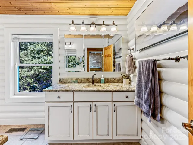 a bathroom with a sink a vanity and a large mirror