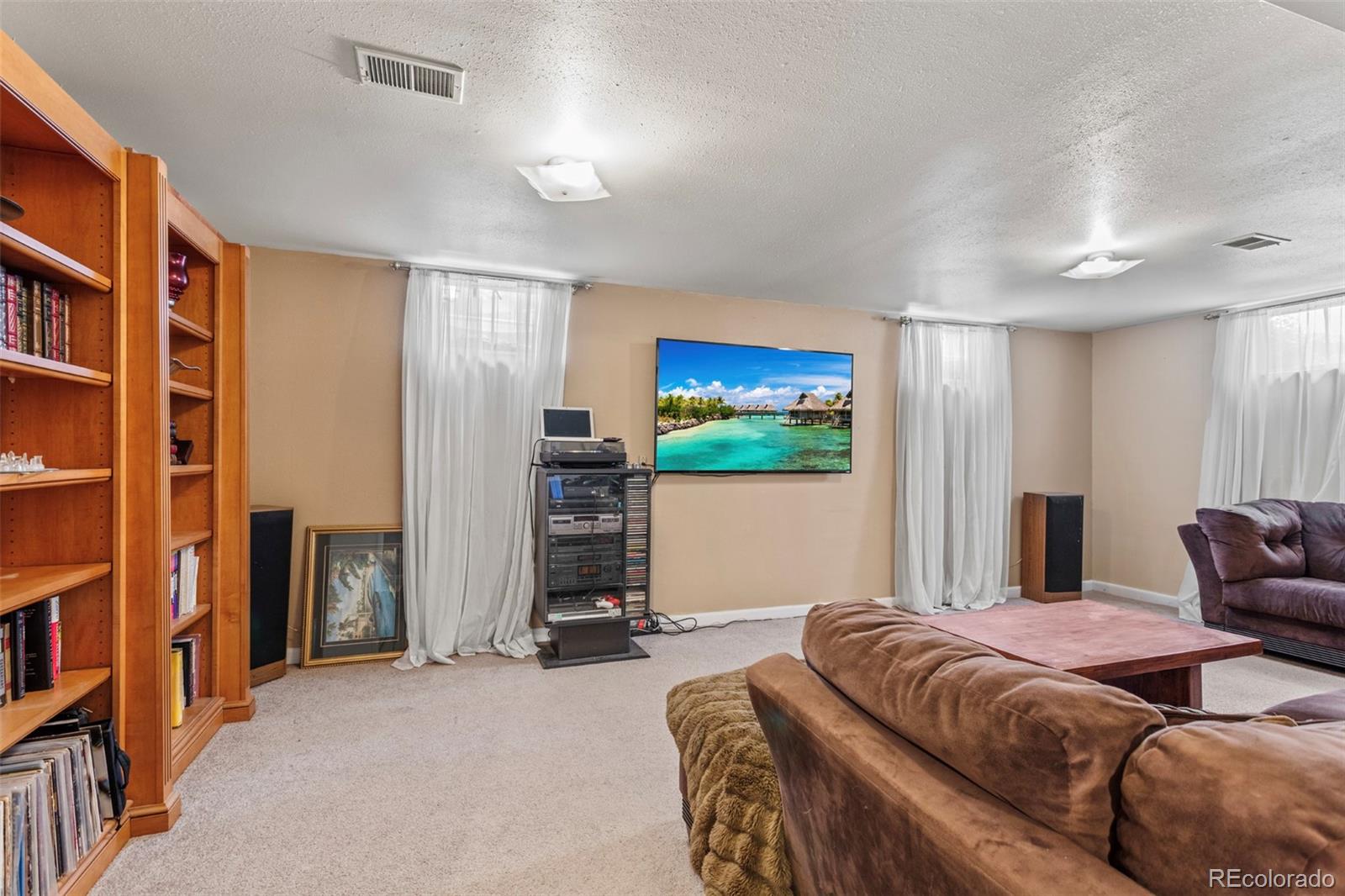 7296 Raritan Street Denver, CO 80221 - Photo 18 of 23 a spacious bedroom with a bed and a flat screen tv