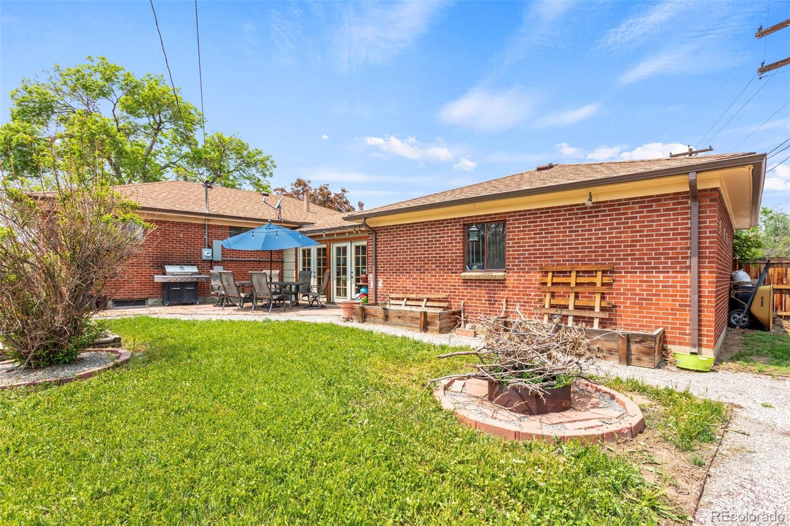 7296 Raritan Street Denver, CO 80221 - Photo 22 of 23 a front view of a house with a garden and patio