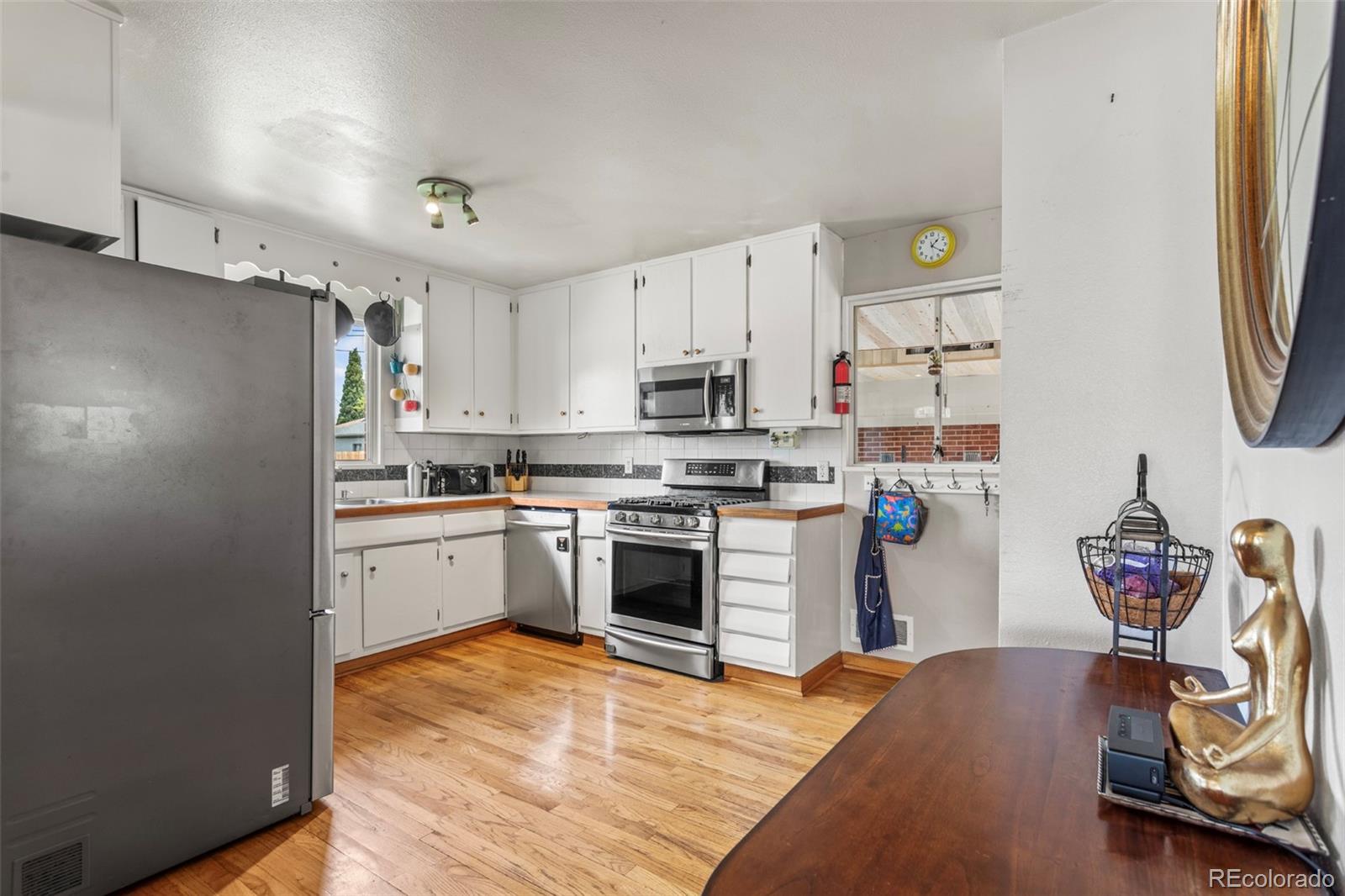 7296 Raritan Street Denver, CO 80221 - Photo 6 of 23 a kitchen with stainless steel appliances granite countertop a refrigerator and a stove top oven