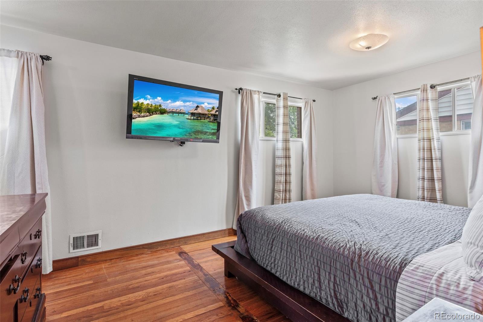 7296 Raritan Street Denver, CO 80221 - Photo 9 of 23 a bedroom with a bed and a flat screen tv