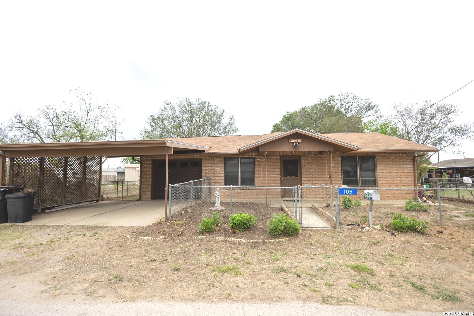 105 South Sayers Drive Devine, TX 78016 - Photo 1 of 23 a front view of a house with a yard and seating space