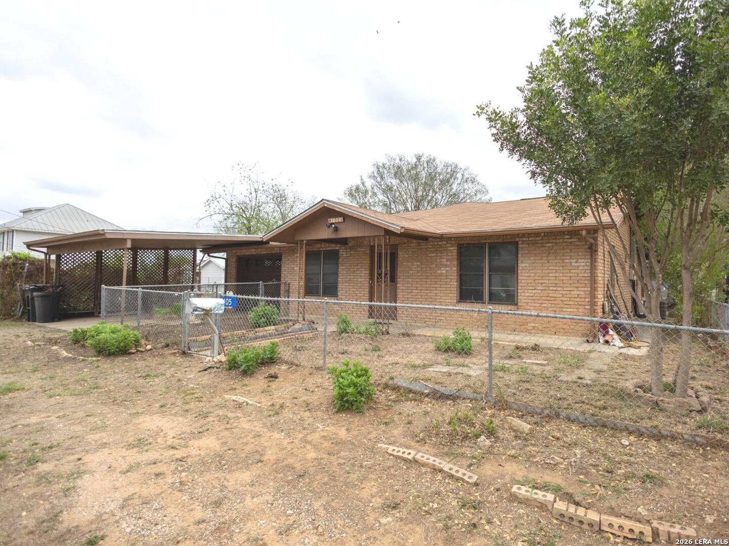 105 South Sayers Drive Devine, TX 78016 - Photo 2 of 23 a front view of a house with garden