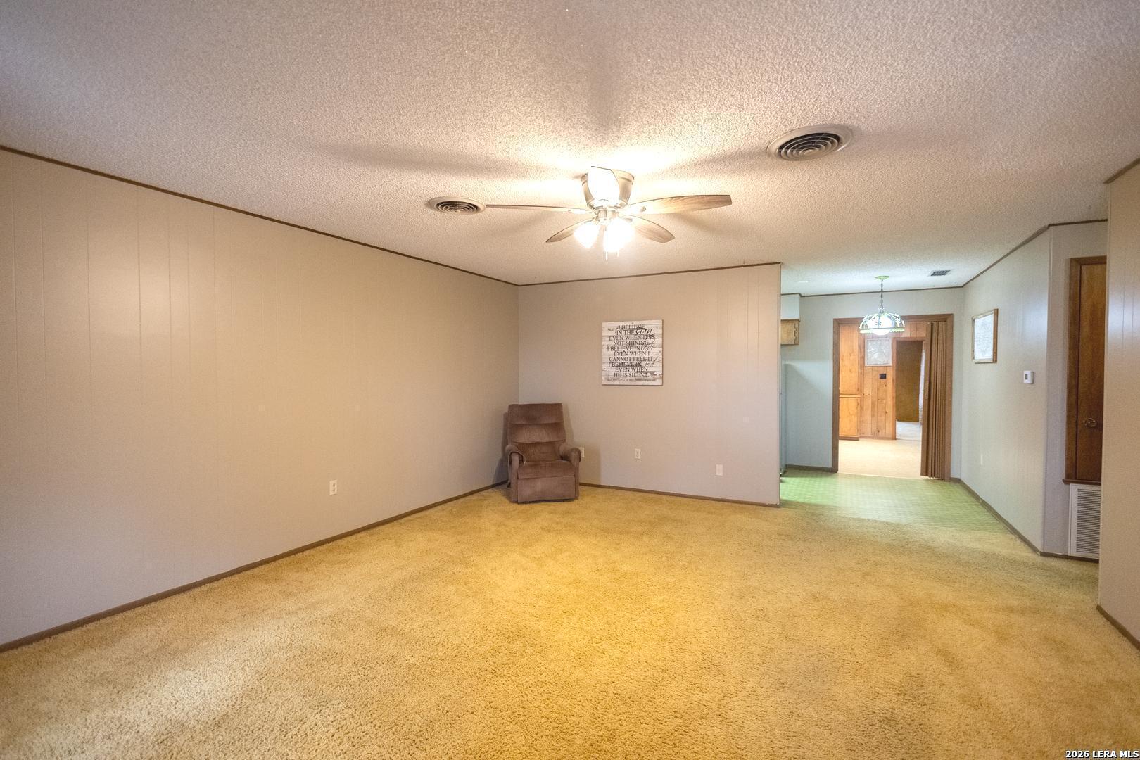 105 South Sayers Drive Devine, TX 78016 - Photo 3 of 23 a view of an empty room with a chandelier fan