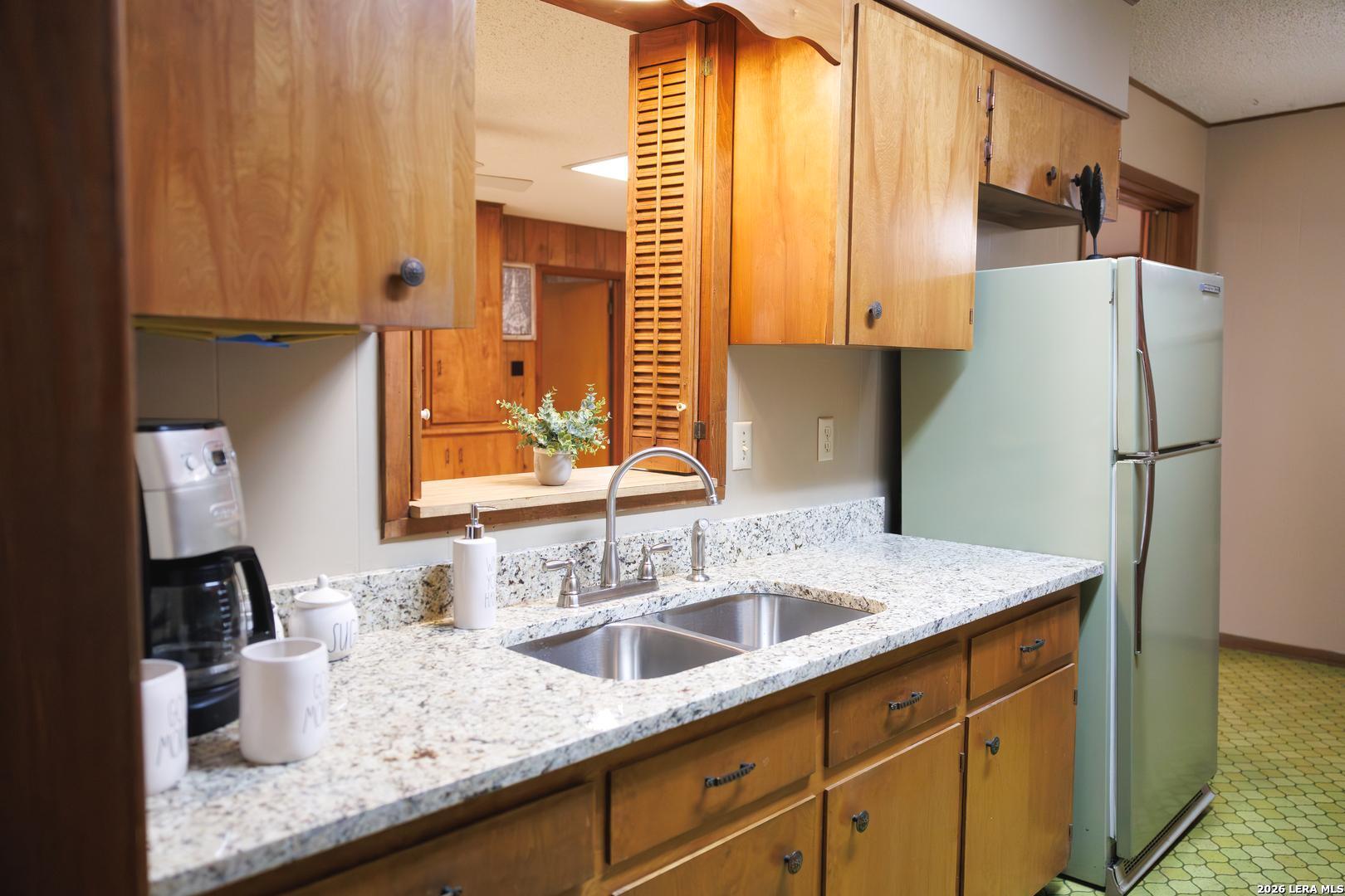 105 South Sayers Drive Devine, TX 78016 - Photo 5 of 23 a kitchen with stainless steel appliances granite countertop a sink and a refrigerator