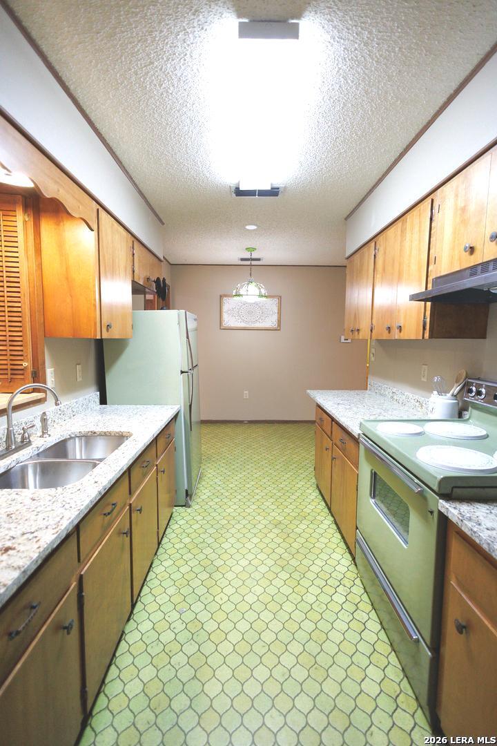 105 South Sayers Drive Devine, TX 78016 - Photo 7 of 23 a large kitchen with kitchen island granite countertop a sink and a stove