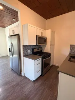 a kitchen with stainless steel appliances granite countertop a sink a stove and a microwave