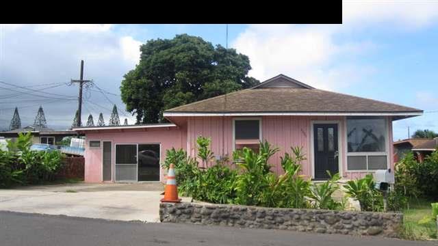 a front view of a house with a yard and potted plants
