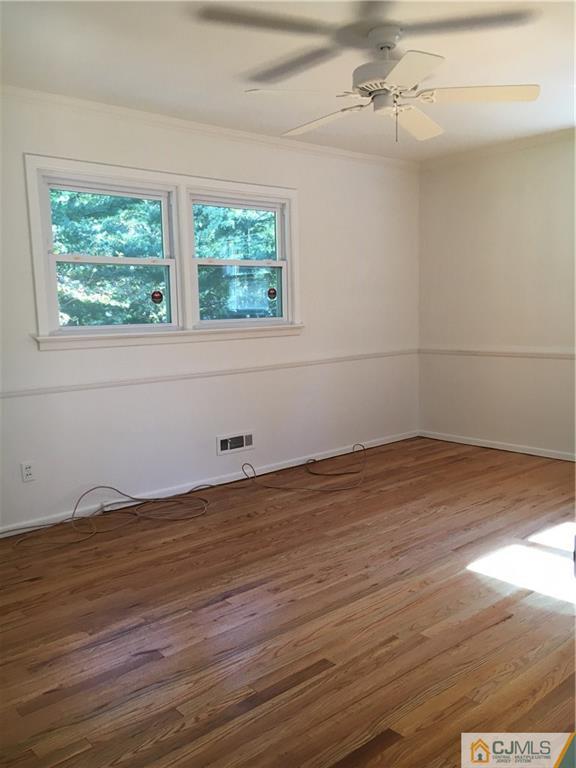 22 Perry Road East Brunswick, NJ 08816 - Photo 5 of 10 an empty room with wooden floor and windows