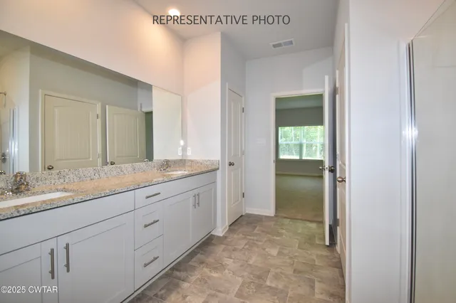 a bathroom with a granite countertop sink mirror and vanity