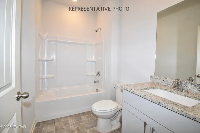 a bathroom with a granite countertop sink a toilet and shower